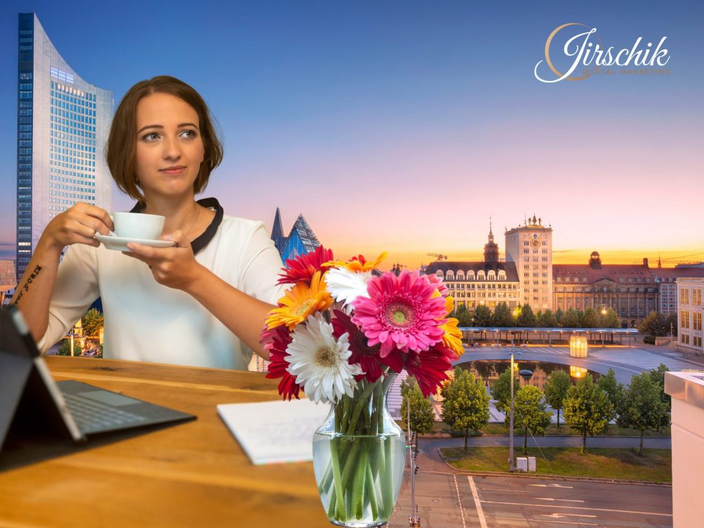 Jessica Jirschik trinkt Kaffee an ihrem Arbeitsplatz, wo sie SEO für Unternehmen in Leipzig anbietet. Zu sehen sind Leipziger Wahrzeichen wie der Uniriese und der Augustusplatz