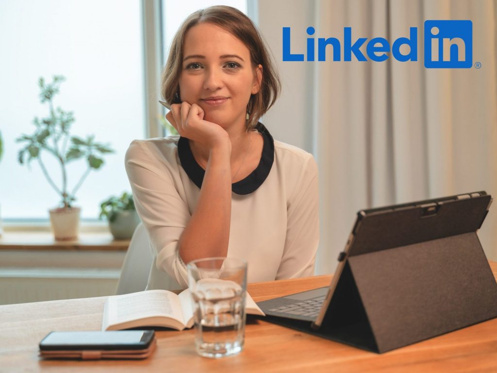 Jessica Jirschik schaut in die Kamera und sitzt an ihrem Arbeitsplatz als Beispiel für gutes Social Media Marketing auf LinkedIn